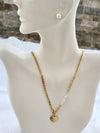 Feminine chain necklace including pearl stud earrings.