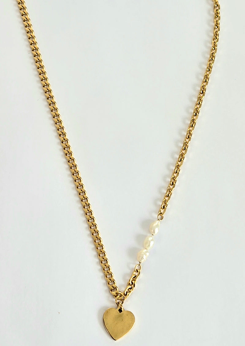 Feminine chain necklace including pearl stud earrings.